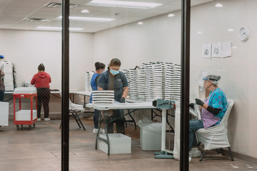 Four women working in warehouse packaging things