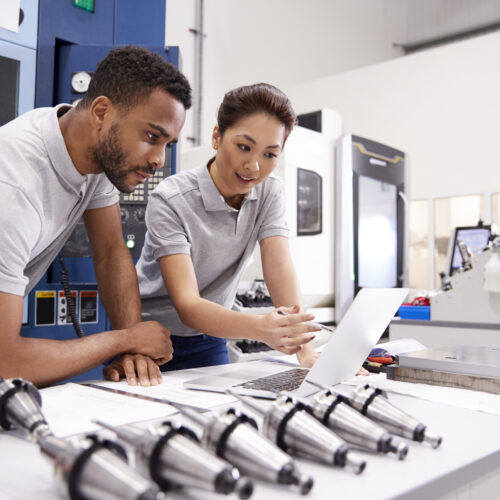 Two Engineers Using CAD Programming Software On Laptop