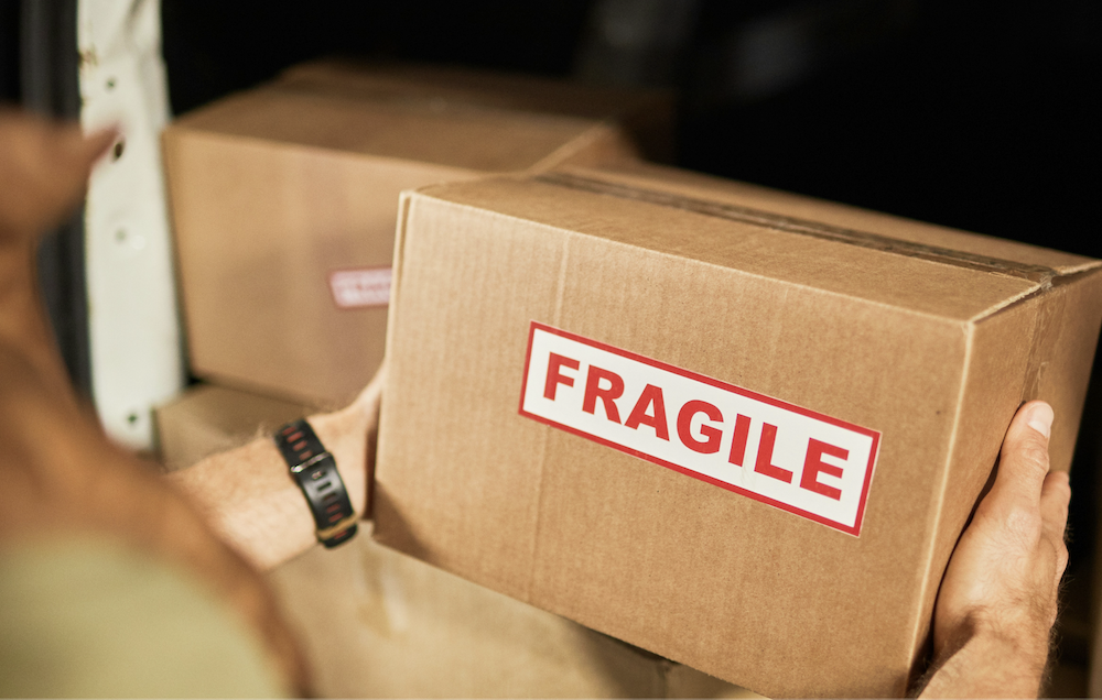 Person handling fragile package in delivery van