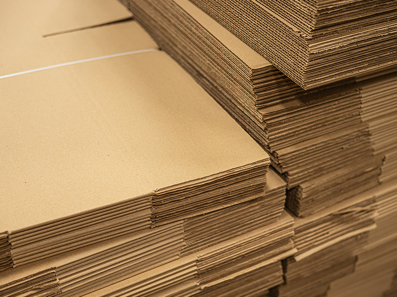 Stacks of brown corrugated cardboard sheets piles