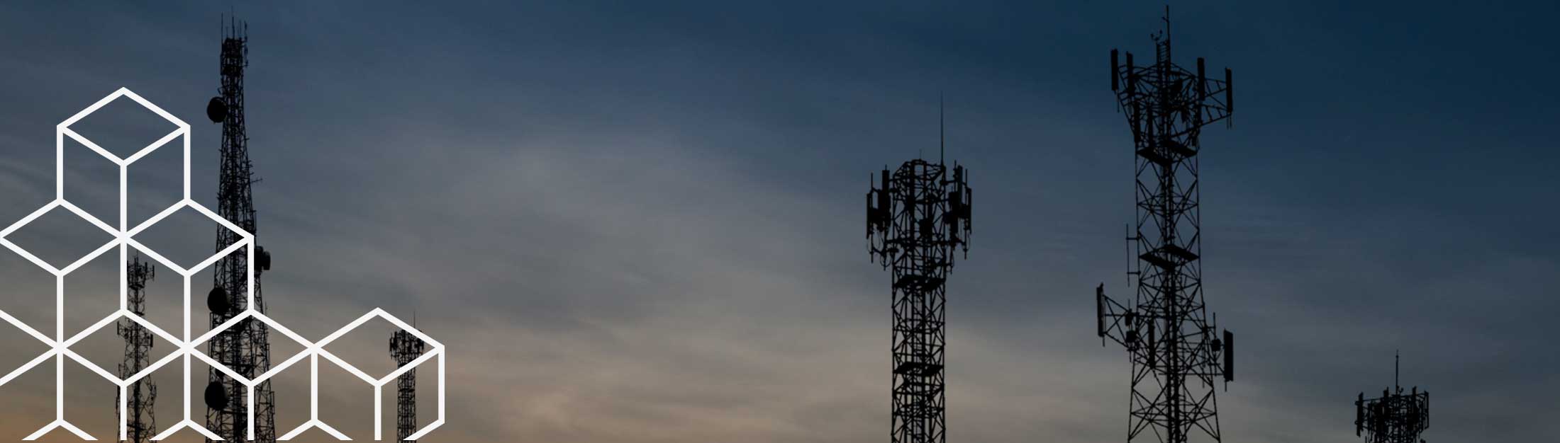Cell towers silhouetted against evening sky backdrop