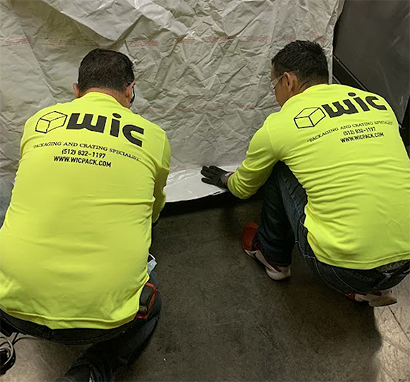 Workers handling packaging materials in a warehouse